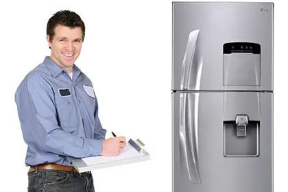 Tecnico sorridente con badge tiene un foglio accanto a un frigorifero LG grigio con sportello aperto.