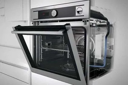 Forno LG con sportello aperto e componenti interni visibili, in ambiente bianco.
