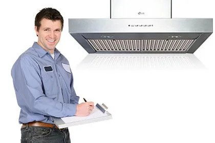 Tecnico sorridente con tesserino accanto a una cappa aspirante LG da cucina su sfondo bianco.